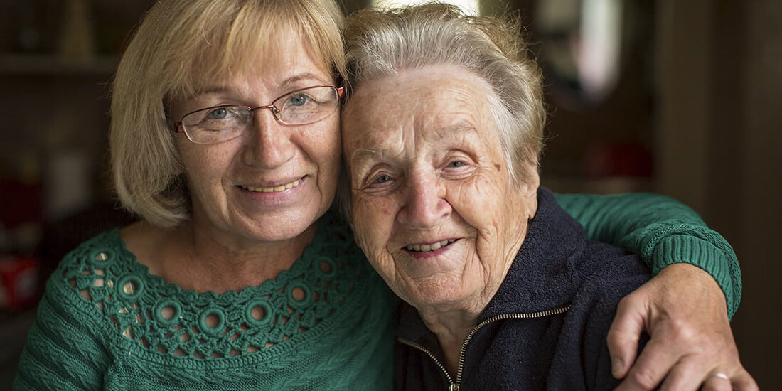 older mother and daughter hugging.